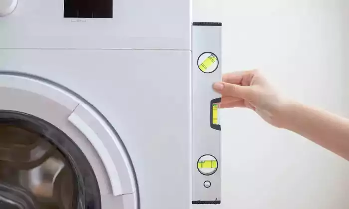 تراز کردن ماشین لباسشویی با ابزار تراز از پهلو